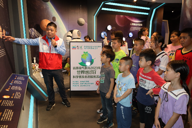 图为:县气象局讲解员在为参观群众介绍八大行星知识(县气象局 卢美兰 摄).JPG