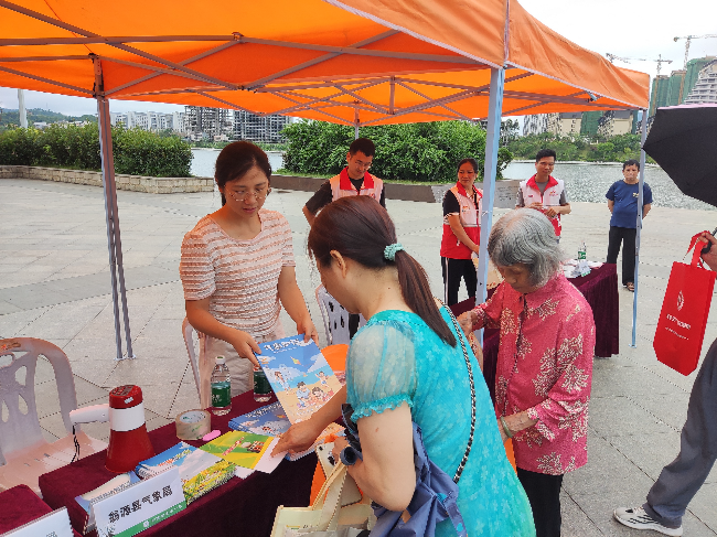 图为：县气象局工作人员发放科普宣传资料（县气象局 余辉 摄）.jpg